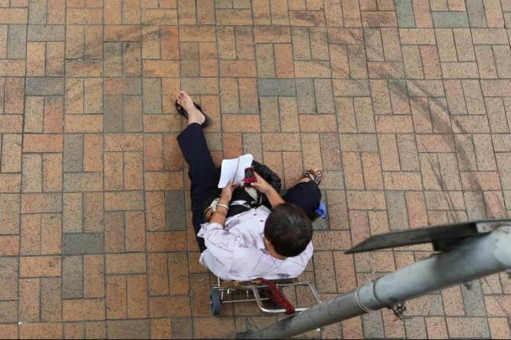 A lone mainland trader sits on his trolley outside Sheung Shui station in the relative calm yesterday following the round-up of 131 traders on Wednesday. Photo: Sam Tsang