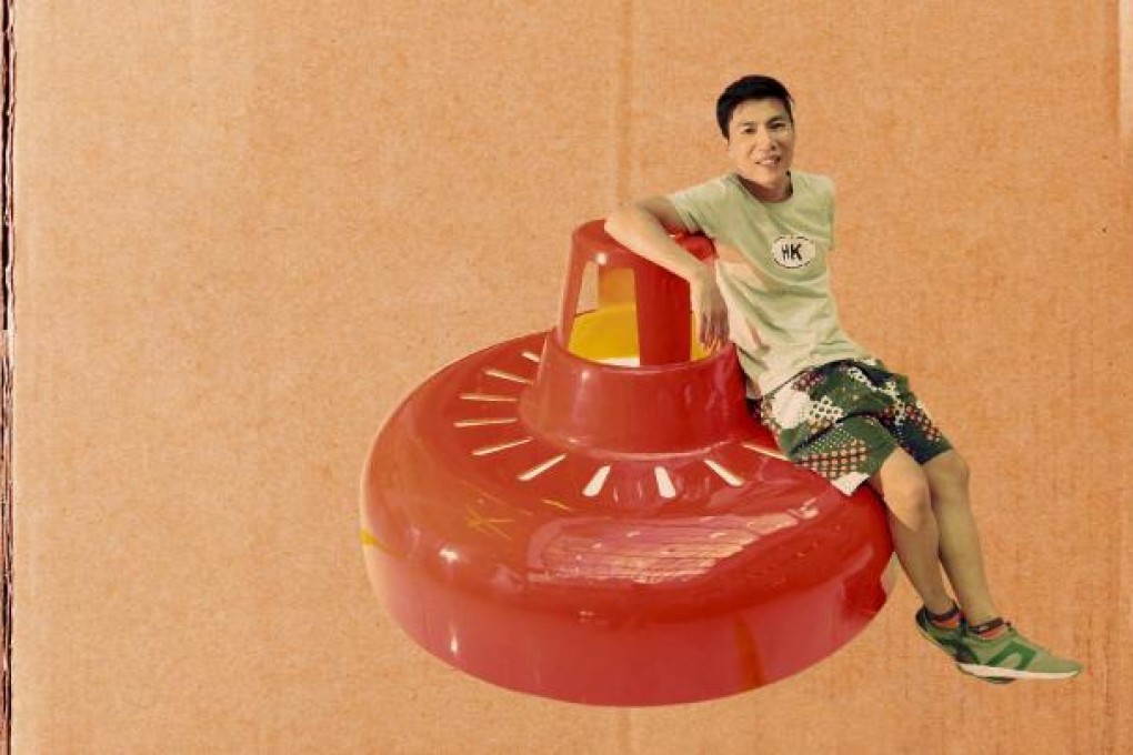 G.O.D. founder Douglas Young relaxes on one of his red lamp chairs at the exhibition, which celebrates Hong Kong's street markets.