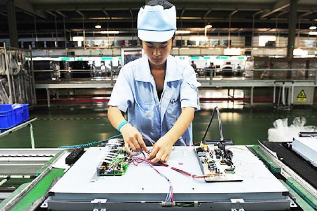 A worker assembles a television set along an assembly line in a Shenyang factory, in Liaoning province. Photo: EPA