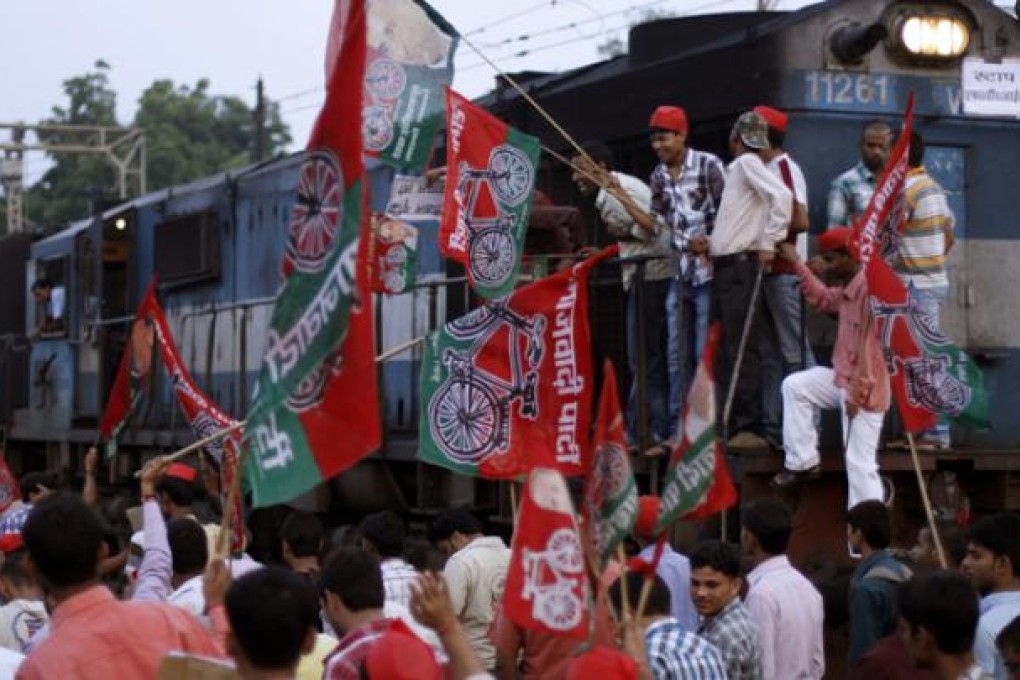 Samajwadi Party activists hold party flags and block a railway track during a protest in Allahabad, India, on Thursday. Photo: AP