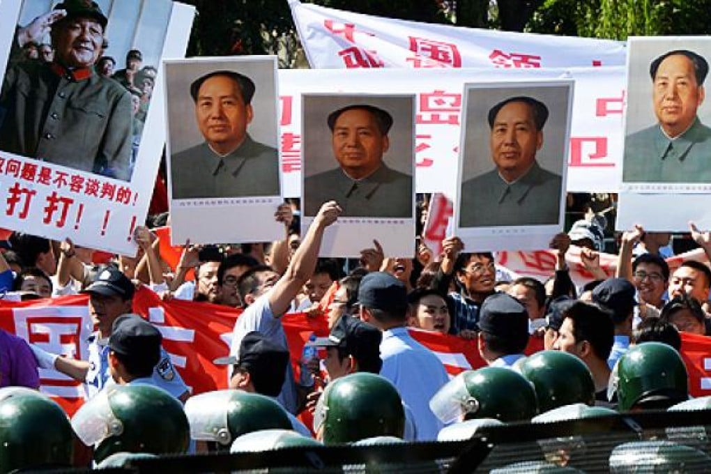 Demonstrators carry Deng Xiaoping (left) and Mao Zedong portraits during a protest over the Diaoyu islands outside the Japanese embassy in Beijing on Tuesday. Photo: AFP