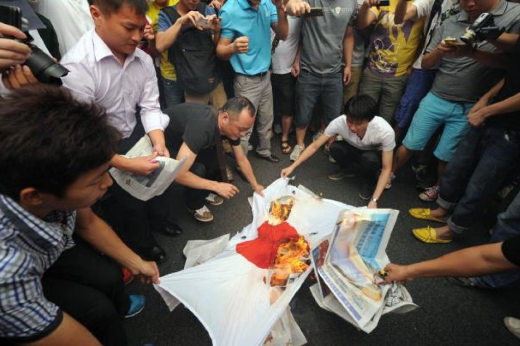 Protesters burning a Japanese flag in Shenzhen. Photo: AFP