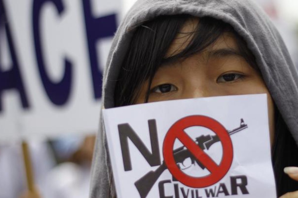 A woman urges peace at a rally in Yangon. Photo: Reuters