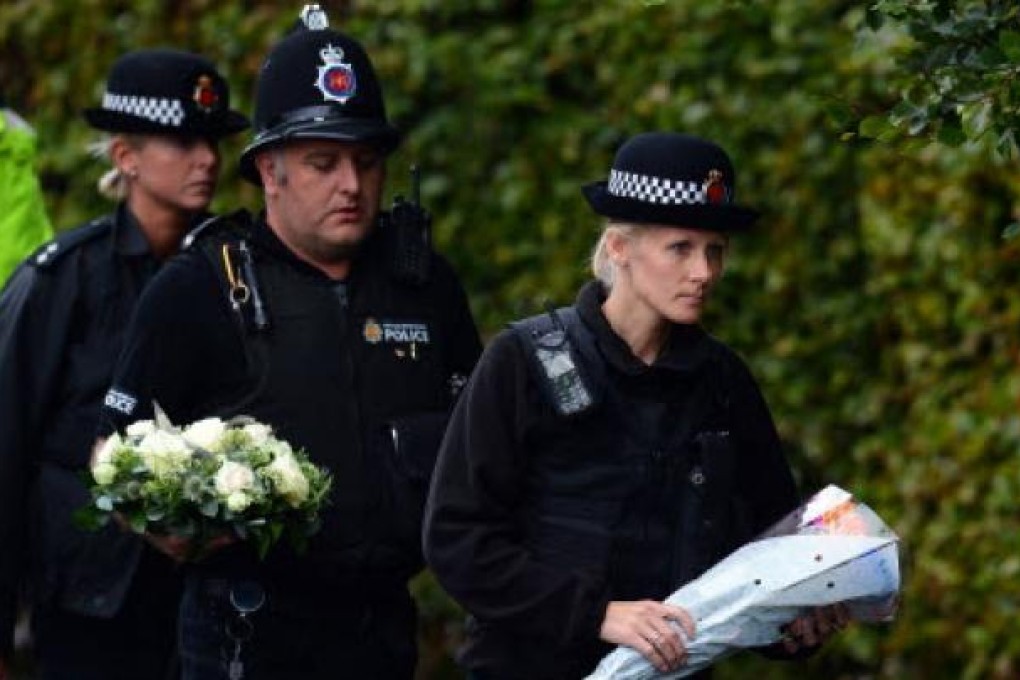 British police officers arrive to lay flowers as tributes close to where two female police officers were killed while answering a routine call-out to the Hattersley estate in Mottram, Tameside, Greater Manchester. Photo: AFP