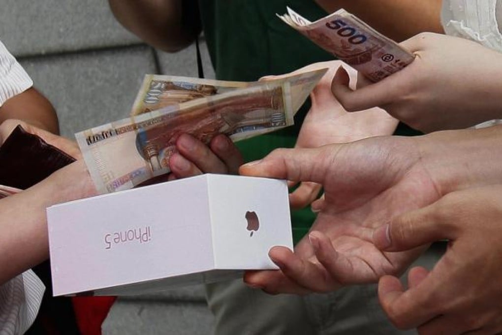 A customer who bought an iPhone 5 from a store in Hong Kong sells it to a trader who will resell it for at least HK$1,200 more. Photo: Reuters