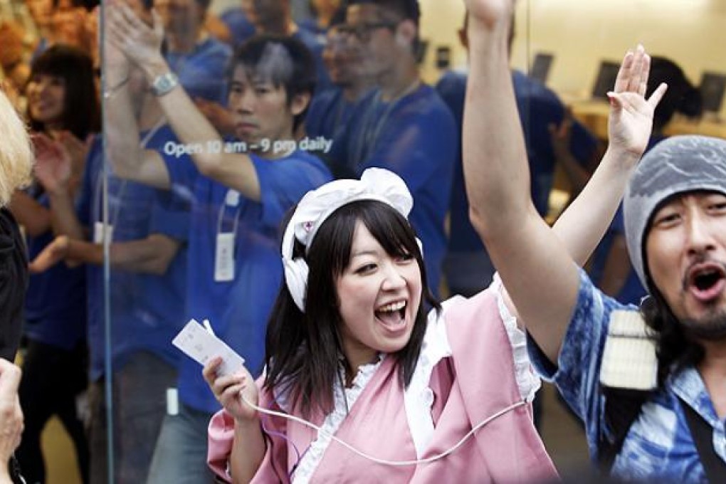 Apple fans celebrate the arrival of the new iPhone 5 at a Tokyo store. Photo: AP