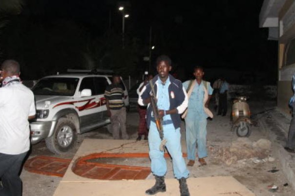 Somali soldiers guard the site of suicide attacks in Mogadishu. Two suicide bombers walked into a restaurant in Mogadishu and killed at least 15 people on Thursday. Photo: Xinhua