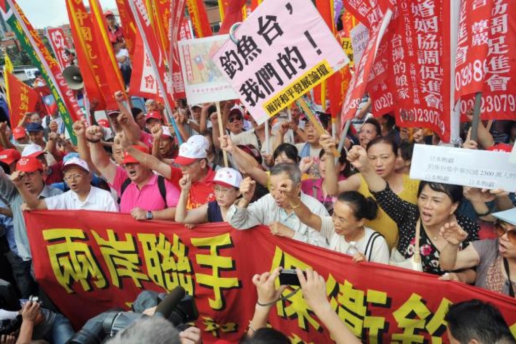 Taiwanese protesters from several right-wing parties and civil groups clutch anti-Japanese placards in Taipei yesterday. Photo: AFP