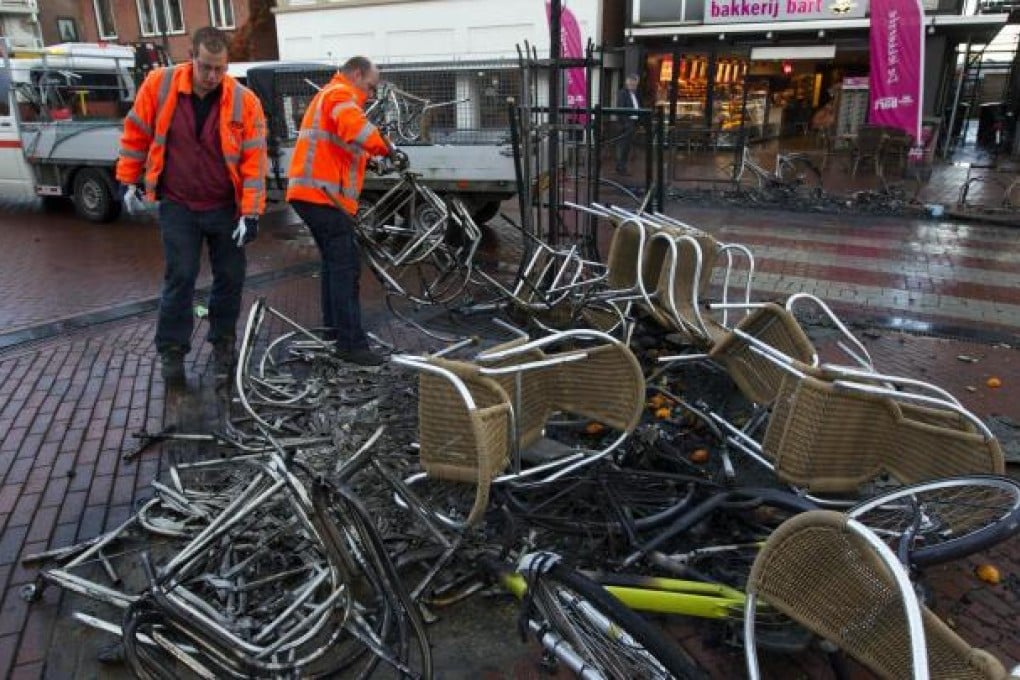 Workers clean up debris in Haren after police clashed with hundreds of youths who tried to crash a girl's 16th birthday party. Photo: AFP