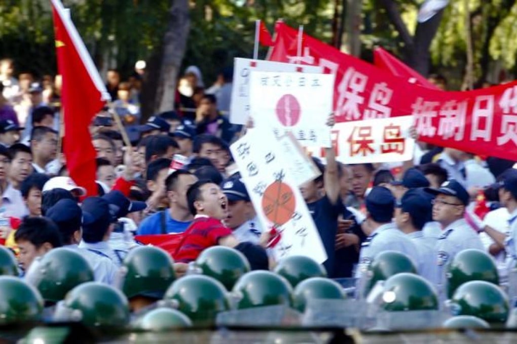 A Chinese demonstrator throws an object at the Japanese embassy in Beijing. Protests against Japan's claim to the disputed Diaoyu Islands had swept across much of China. Photo: EPA