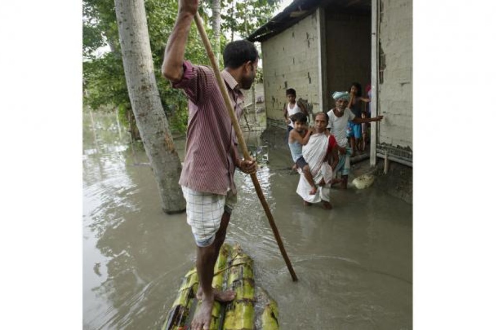 A man uses a banana raft to ferry villagers. Photo: AP