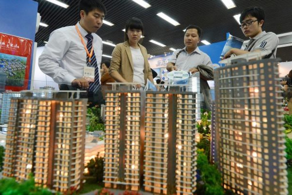 People view a model of a property development being sold at the Beijing Property and Investment Show on September 20, 2012. Photo: AFP