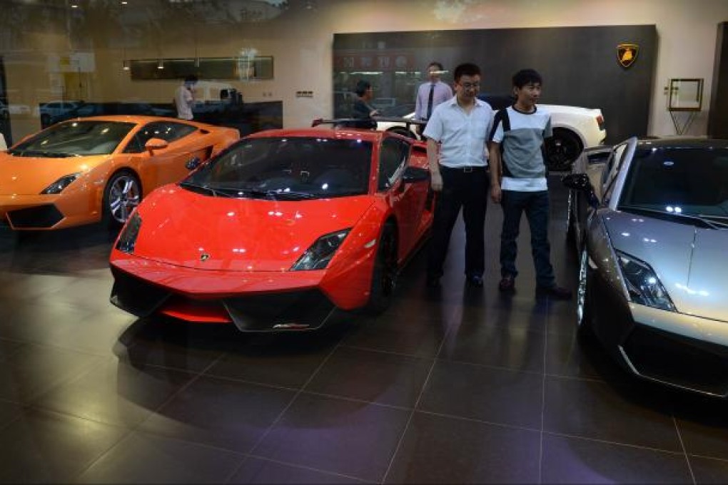 Chinese men look at luxury European sports cars at a showroom in Beijing on September 4, 2012. Photo: AFP