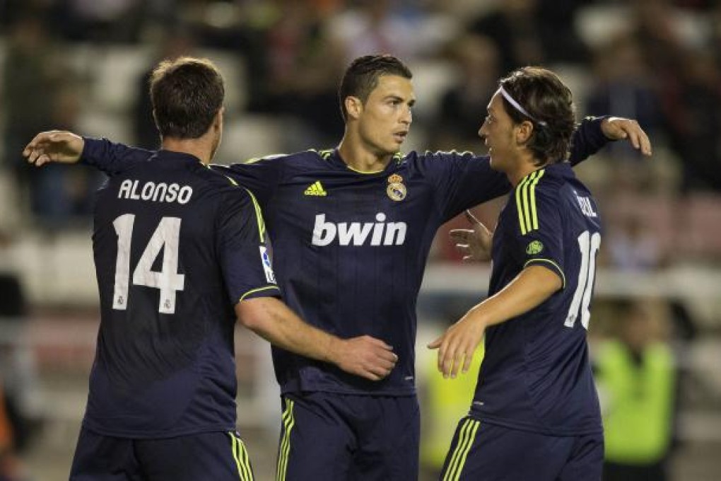 Real Madrid's Cristiano Ronaldo (C) celebrates with team mates Xabi Alonso (L) and Mesut Ozil.  Photo: AFP