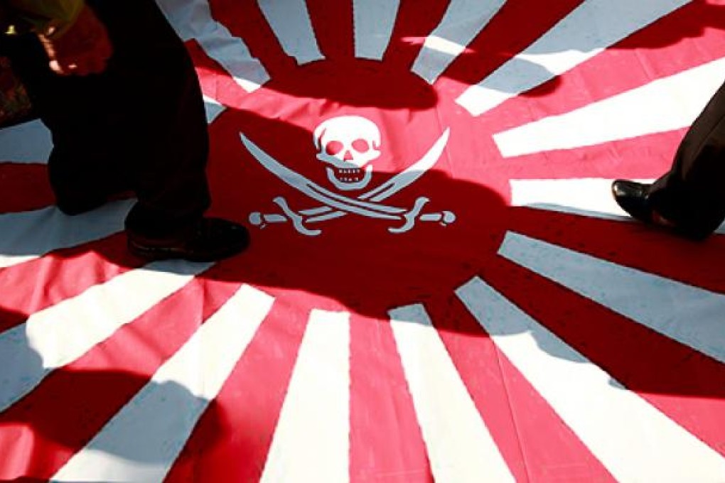 Protesters in Seoul, trample on a flag representing Japan during demonstrations outside the Japanese embassy on Monday. Photo: EPA