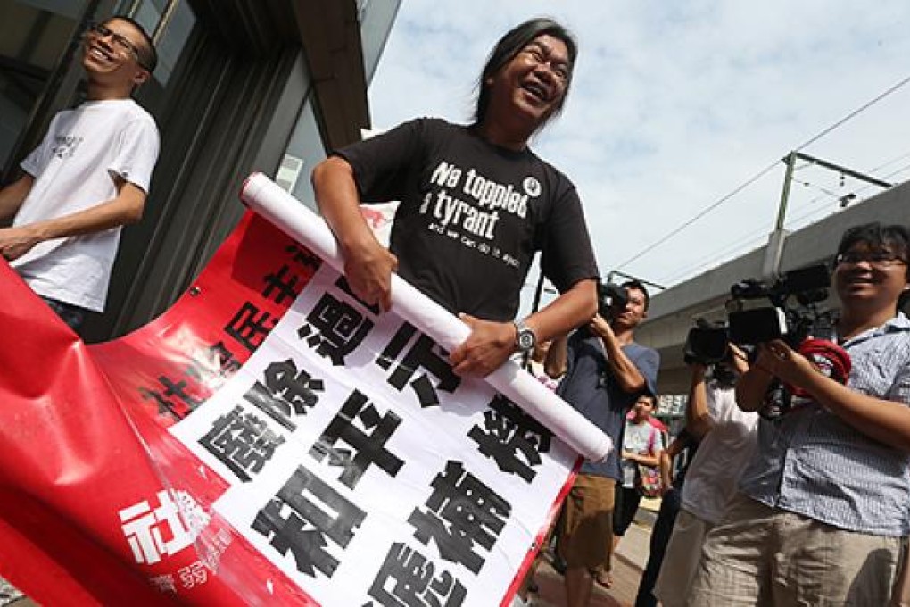 Radical lawmaker “Long Hair” Leung Kwok-hung rolls up a protest sign on Tuesday outside Kwun Tong Court. Photo: Sam Tsang