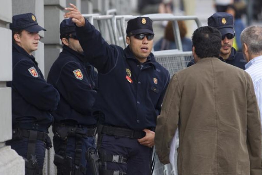 Police guarding the entrance of the Spanish parliament stop people entering the street in Madrid, on Tuesday. Photo: AP