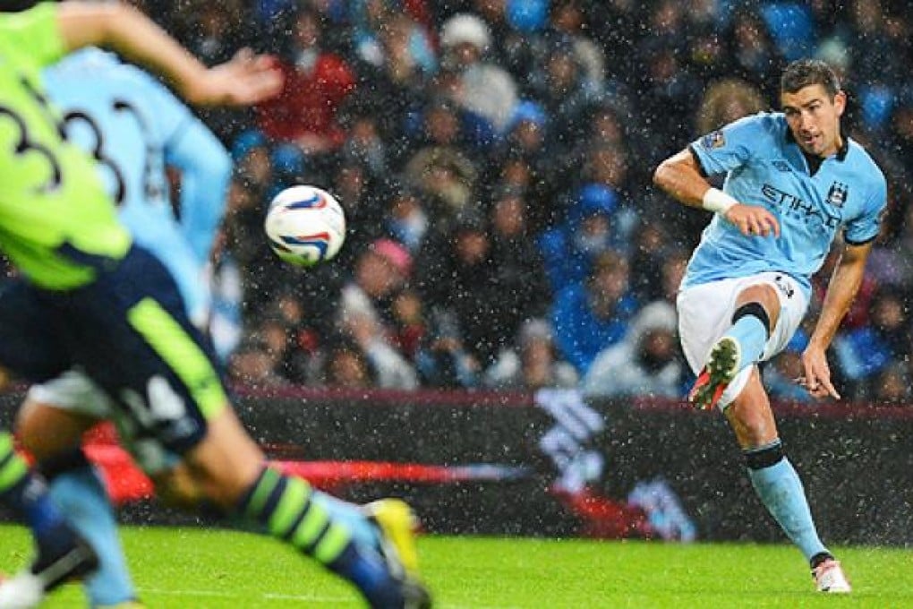 Manchester City's Aleksandar Kolarov shoots to score the second goal in a match against Aston Villa on Tuesday. Photo: AFP