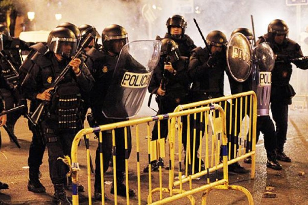 Police shoot rubber bullets at protesters in Madrid on Tuesday. Photo: AP