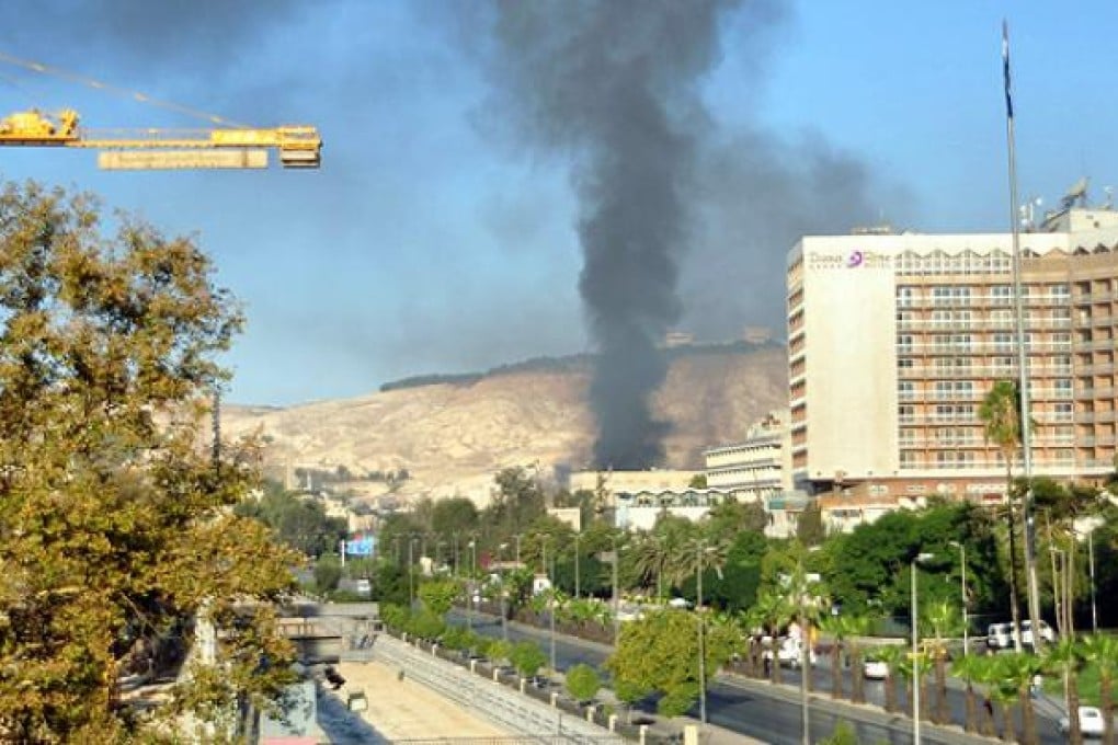 Columns of smoke rise above Umayyad Square district after two powerful explosions rocked Damascus on Wednesday. Photo: EPA