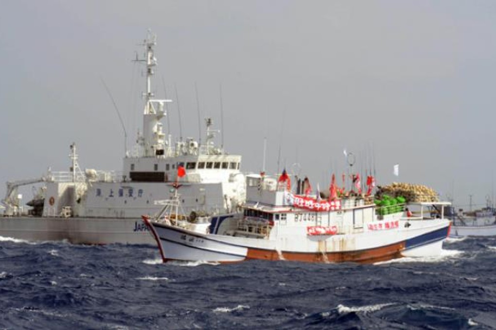 Two Taiwan fishing boats are blocked by a Japan Coast Guard vessel  left, as they try to sail toward the disputed Diaoyu/Senkaku Islands in territorial waters in the East China Sea on Tuesday. Photo: AFP