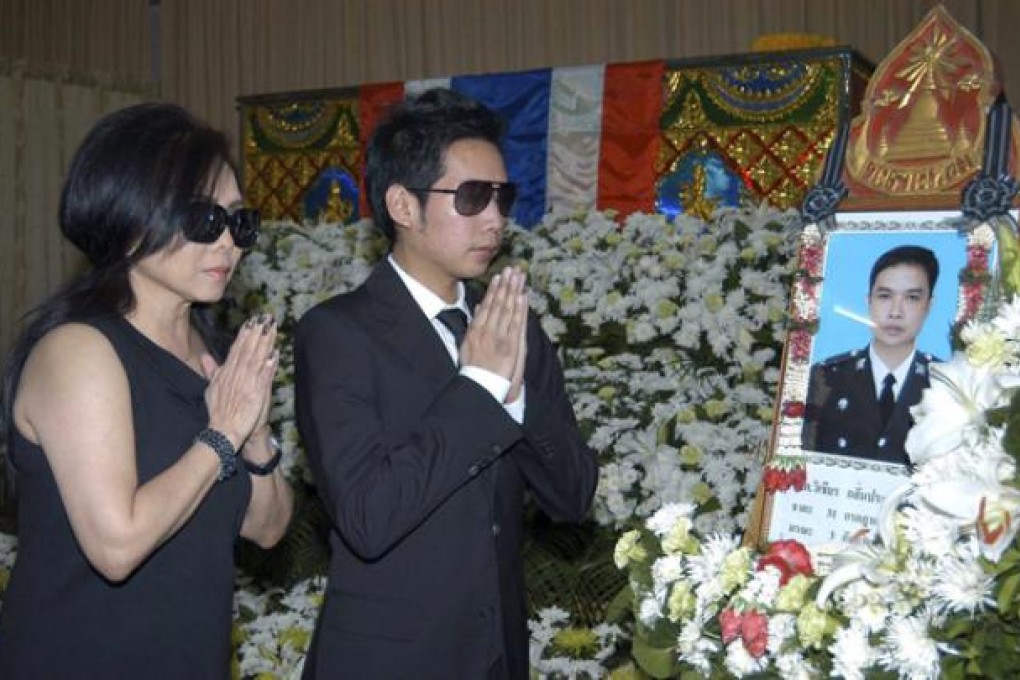 Vorayuth Yoovidhya, right, and his mother Daranee pay their respects to Police Senior Sergeant Major Wichean Klinprasert during a funeral ceremony at a Buddhist temple in Bangkok, on September 5. Photo: EPA