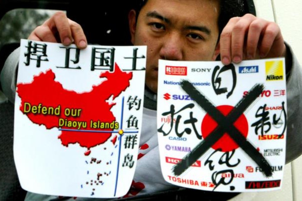 A Chinese demonstrator holds up protest leaflets, which read "Defend our Diaoyu islands" (left) and " Boycott Japanese products".
