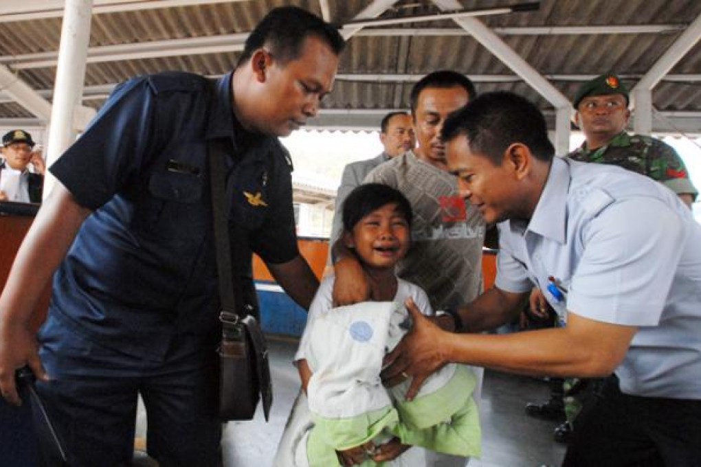 A young survivor of the ferry accident cries as she is escorted by an official at Merak seaport, Banten province on Wednesday. Photo: EPA