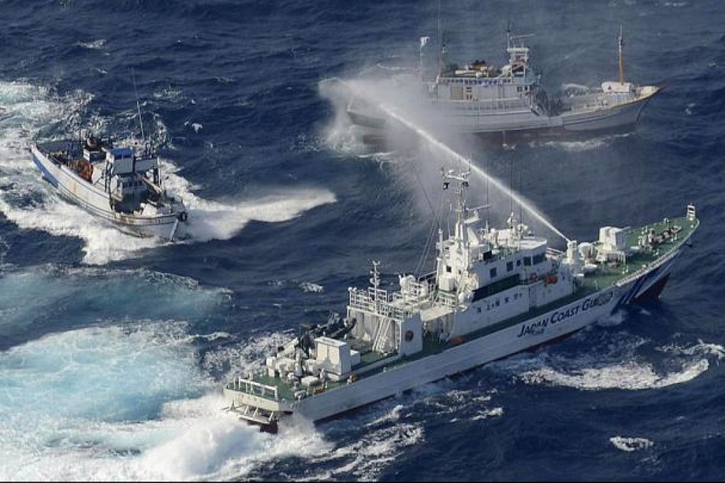 A Japan Coast Guard vessel (lower) sprays water against Taiwanese fishing boats near the Diaoyu islands, which the Japanese call the Senkaku Islands, on Sept.  25, 2012. Photo: AFP