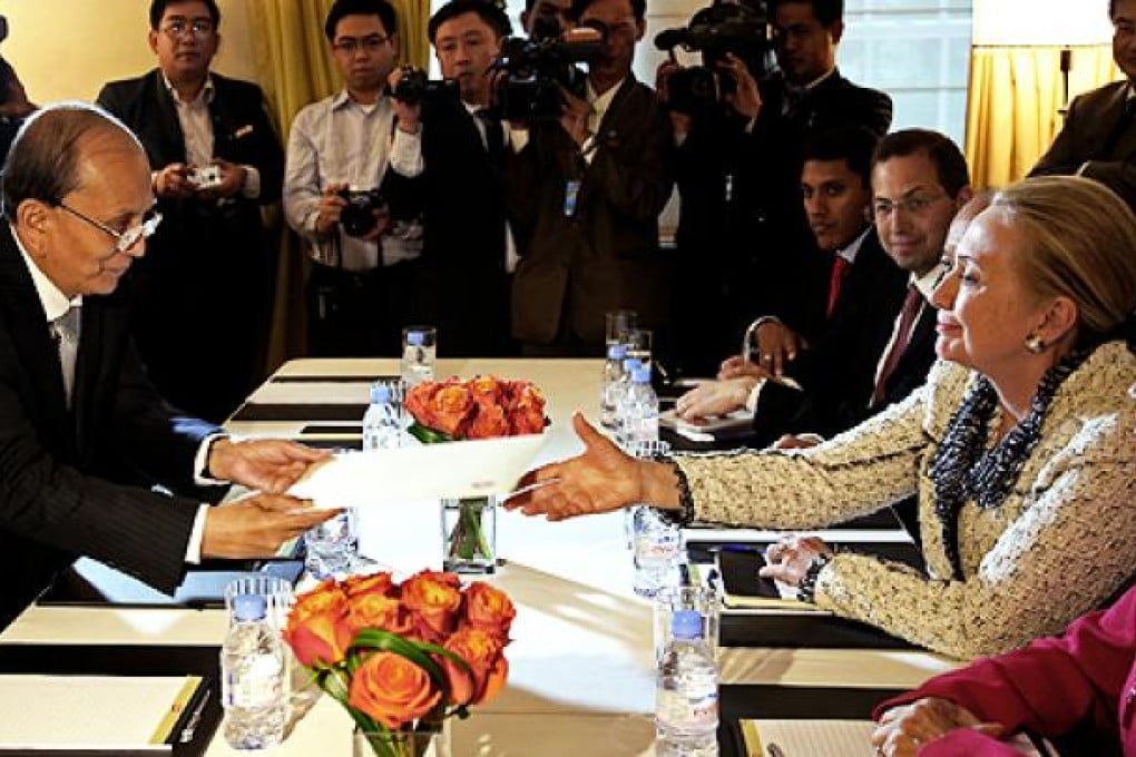 US Secretary of State Hillary Clinton (right) is handed an envelope from Myanmar's President Thein Sein as they meet in New York on Wednesday. Photo: AP