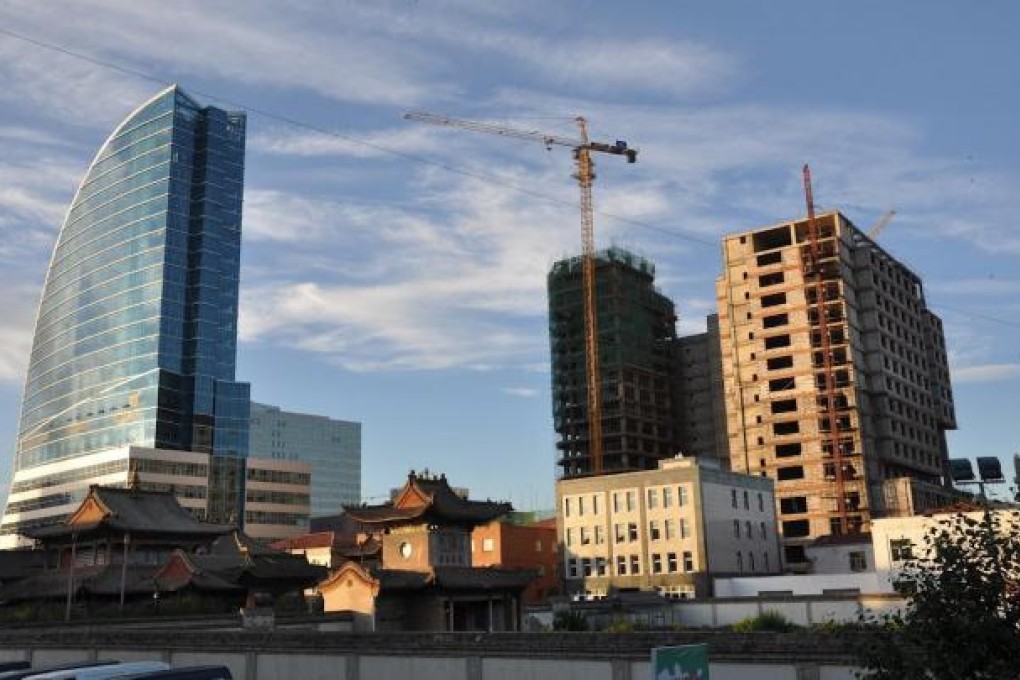 Glass towers and half-finished buildings loom over the ancient Choijin Lama Temple in Ulan Bator. Photo: Michael Kohn
