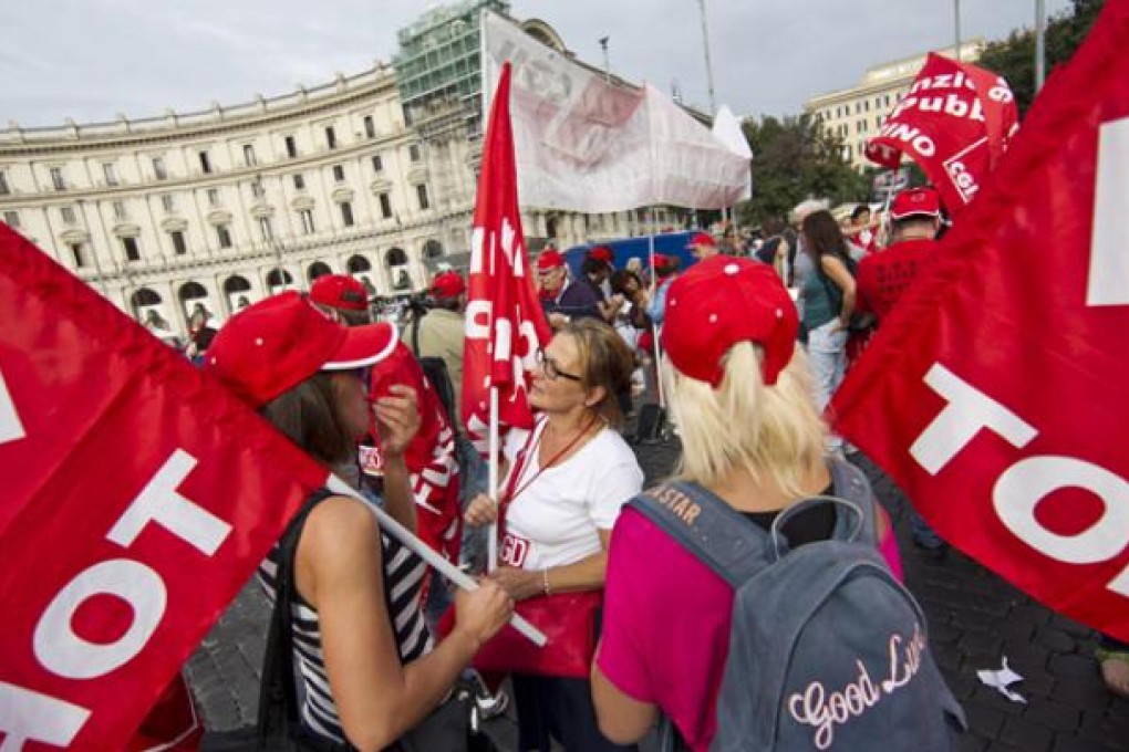 Workers gather on the Piazza della Repubblica in Rome to attend a protest march during a general strike on Friday. Photo: EPA