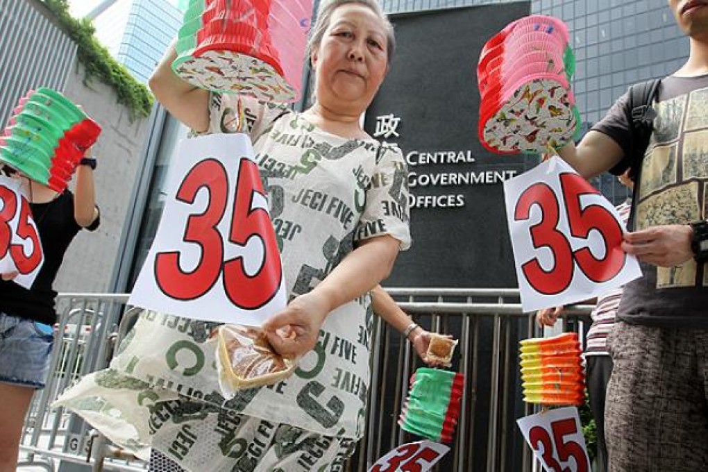 Workers campaign for the minimum wage to be set at HK$35 per hour outside Central Government Offices in Tamar. Photo: May Tse