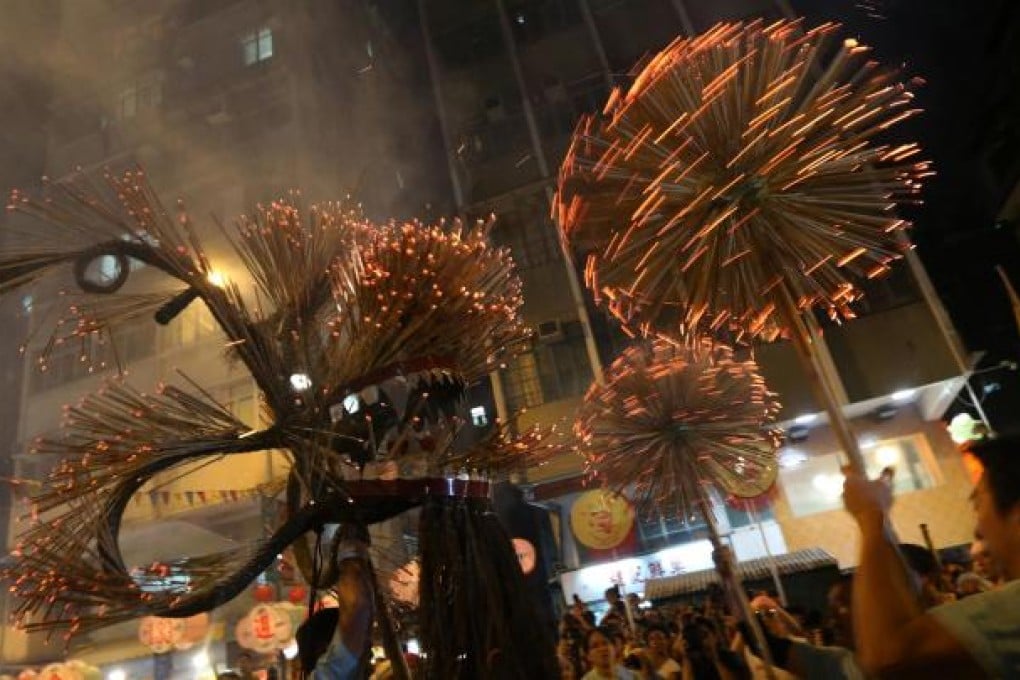 The dragon studded with incense makes its way through Tai Hang in the annual parade. Photo: David Wong