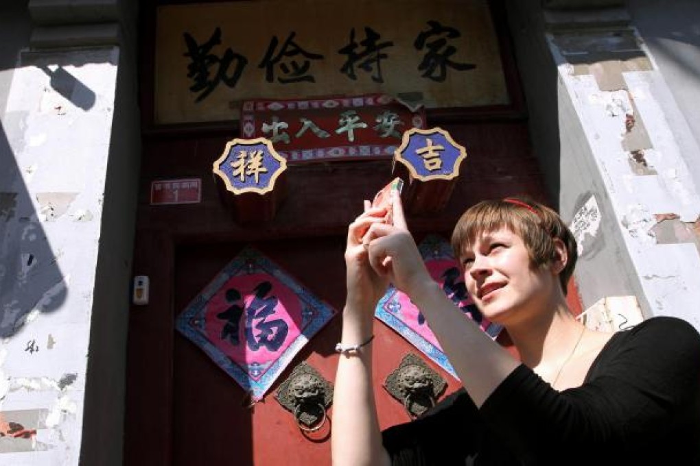 Emily Schreck, known as Beijingemily, takes a photo of a Beijing hutong to share with Chinese and English Instagram fans. Photo: Simon Song