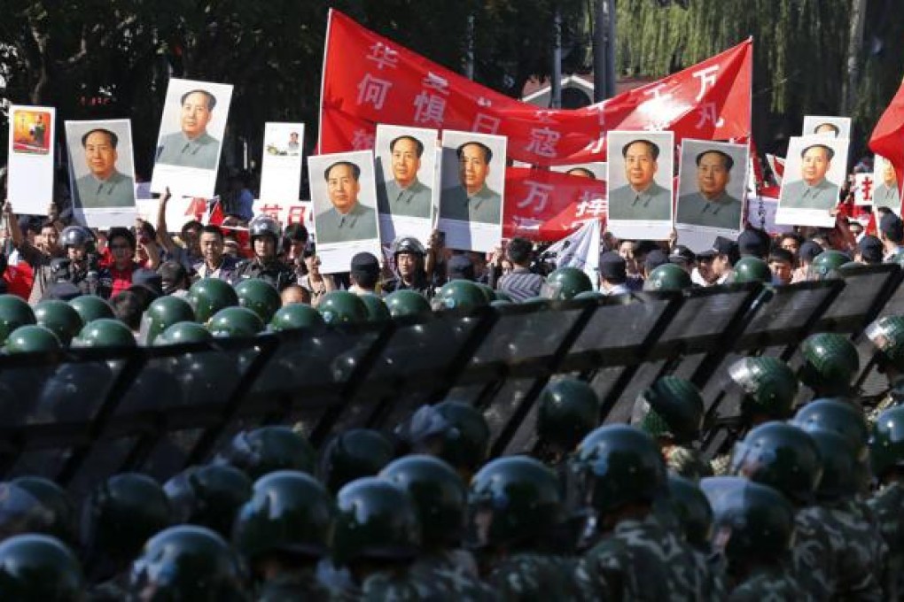 Rows of soldiers stand guard as protesters with portraits of Mao Zedong gather at the Japanese embassy in Beijing. Photo: Reuters