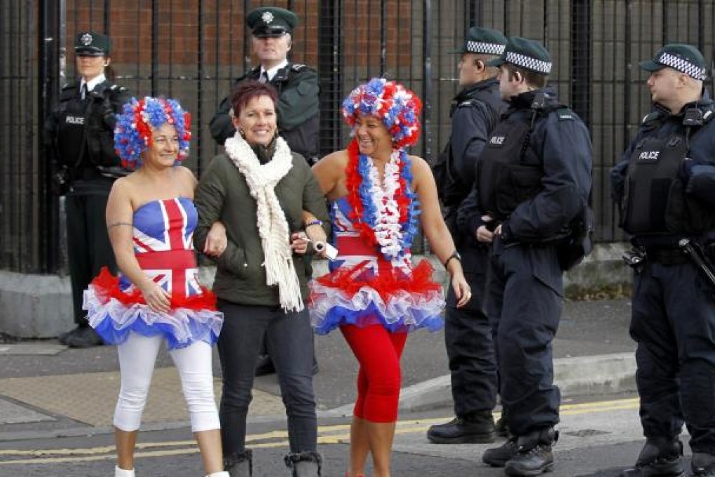 Protestants make their way past policemen in Belfast. Photo: AP