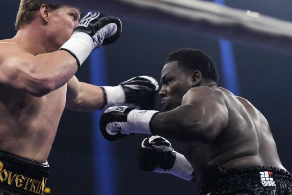 Russia's heavyweight boxer Alexander Povetkin (left) exchanges punches with Hasim Rahman on Saturday. Photo: AFP