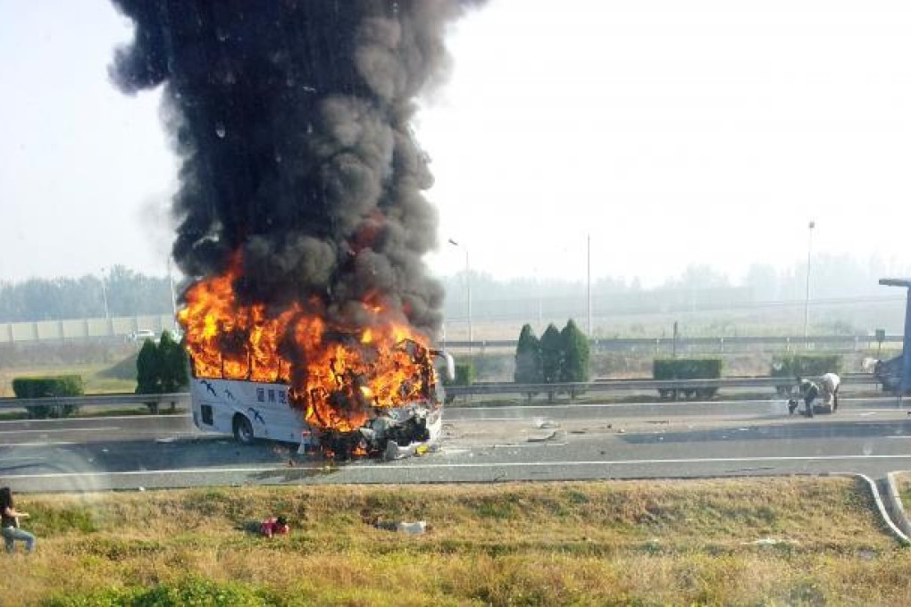 A tourist bus, seen through the window of another vehicle, catches fire after crashing with a truck on the Beijing-Tianjin-Tanggu Expressway in Tianjin October 1, 2012. Photo: Reuters