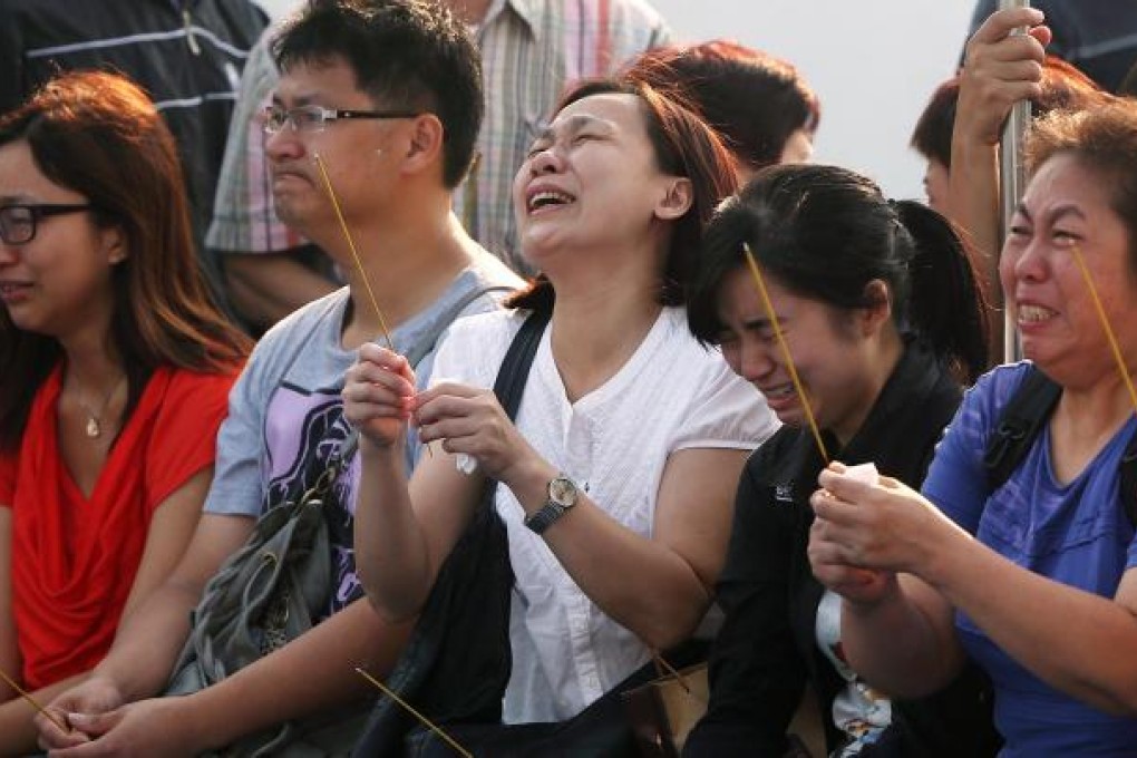 Relatives perform a Taoist ritual for the dead on a boat in waters off Lamma Island. The death toll increased to 38 yesterday but more may be missing, as there was no passenger manifest for the ferry that sank. Photo: Sam Tsang