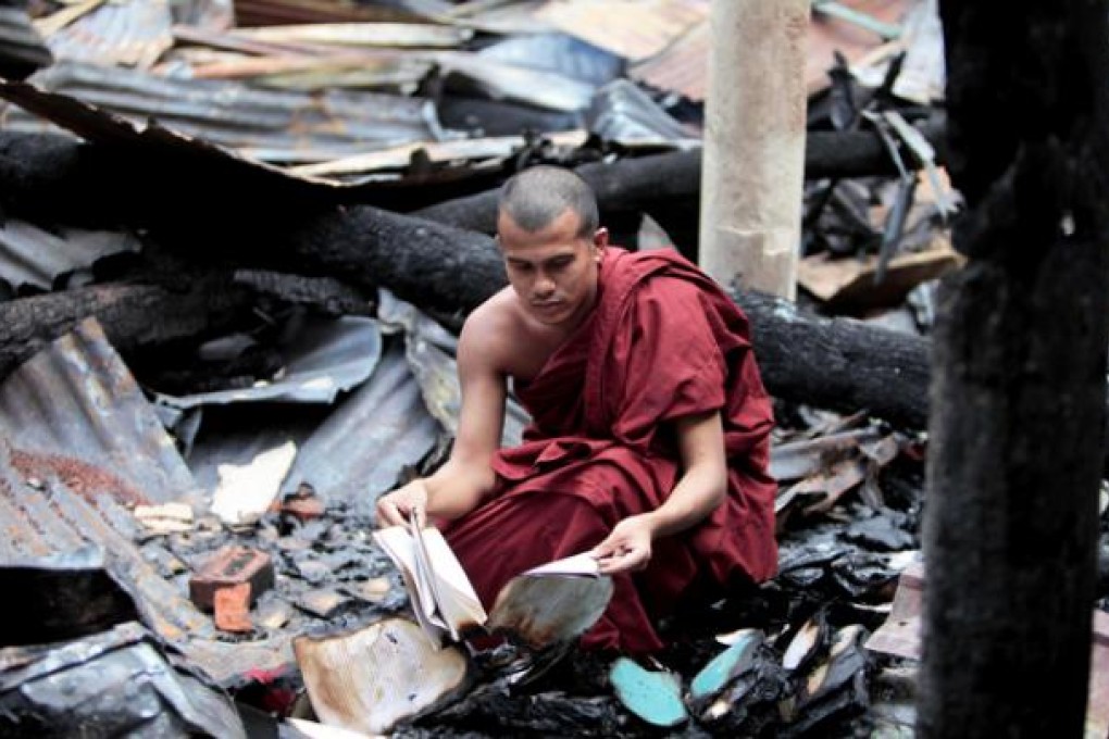 A Bangladeshi Buddhist monk checks the remains of burned religious books at a Buddhist temple that was torched in the coastal district of Cox's Bazar. Photo: AP