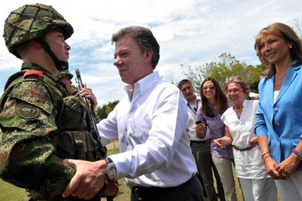 President Juan Manuel Santos (centre) greeting his son Esteban Santos during the delivery of weapons to new soldiers at the Tolemaida Army Base. Photo: AFP