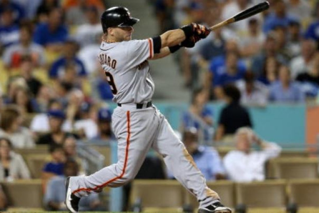 Marco Scutaro #19 of the San Francisco Giants hits an RBI single to tie the score in the eighth inning against the Los Angeles Dodgers on Monday at Dodger Stadium in Los Angeles. Photo: AFP