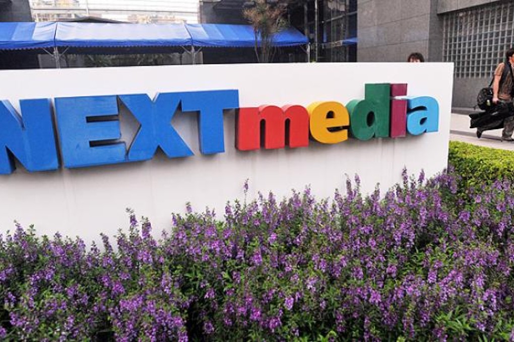 Employees leave the Next Media building in Taipei on Monday. Photo: AFP