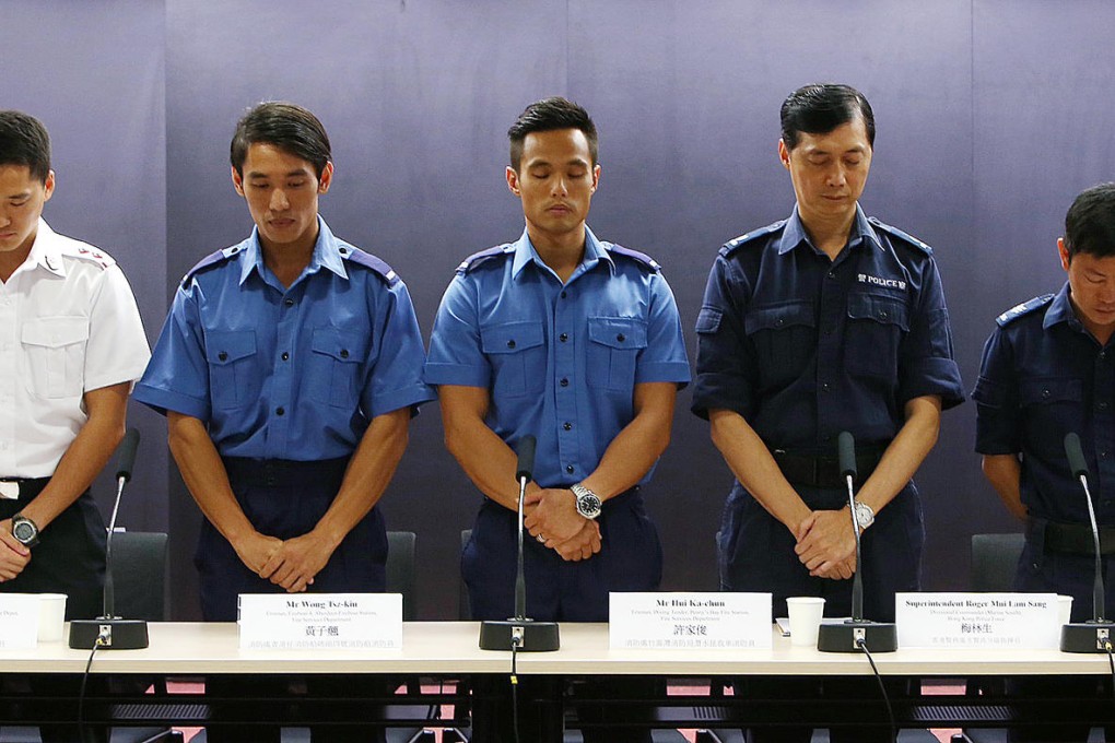 Emergency workers observe a minute silence during the press conference to share experiences about the rescue effort. Photo: Sam Tsang