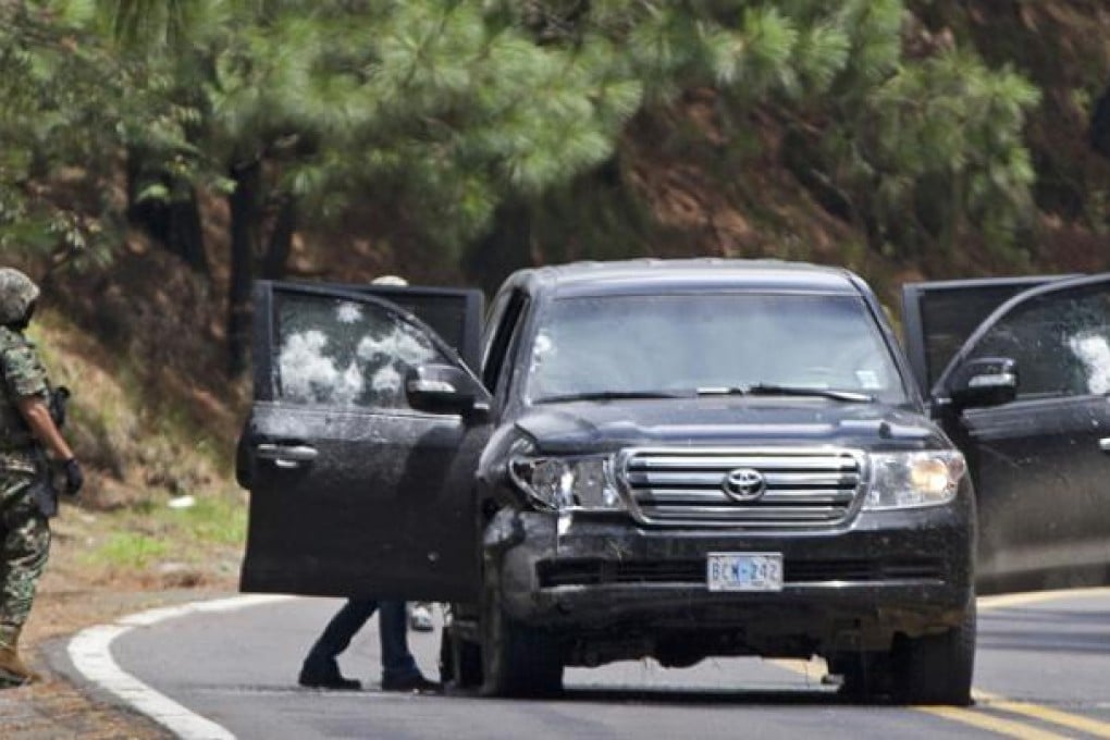 The armoured US embassy vehicle is checked by military personal after it was attacked by unknown assailants on the highway leading to the city of Cuernavaca, near Tres Marias. Photo: AP