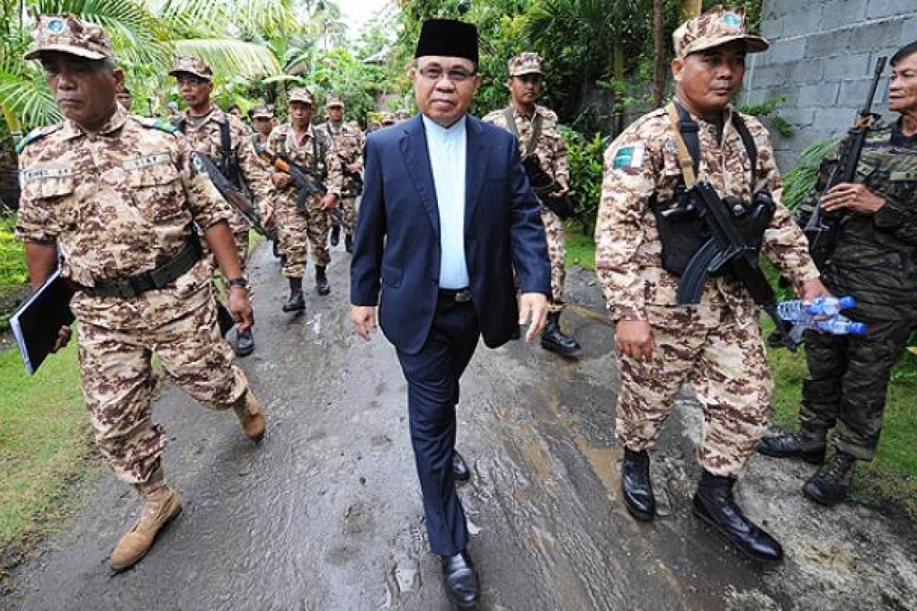 Moro Islamic Liberation Front chairman Murad Ebrahim is escorted by his troops to their base camp in Darapan, Sultan Kudarat province, Philippines. Photo: AFP