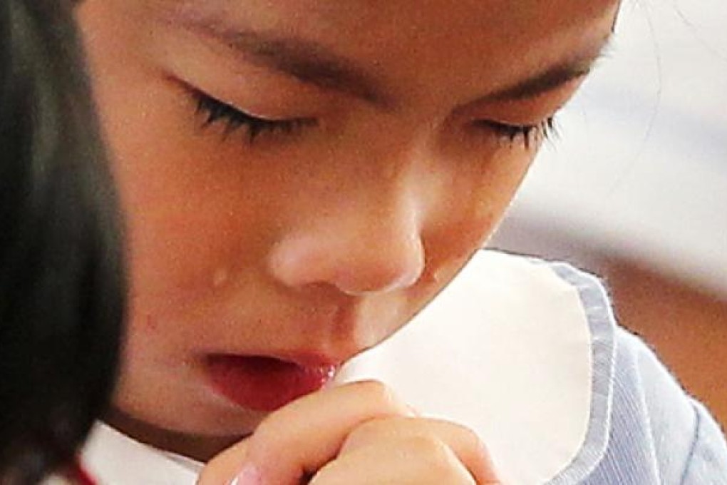 A girl cries in memory of the ferry disaster as Kowloon Tong Government Primary School marks three minutes of silence on Thursday. Photo: SCMP Pictures