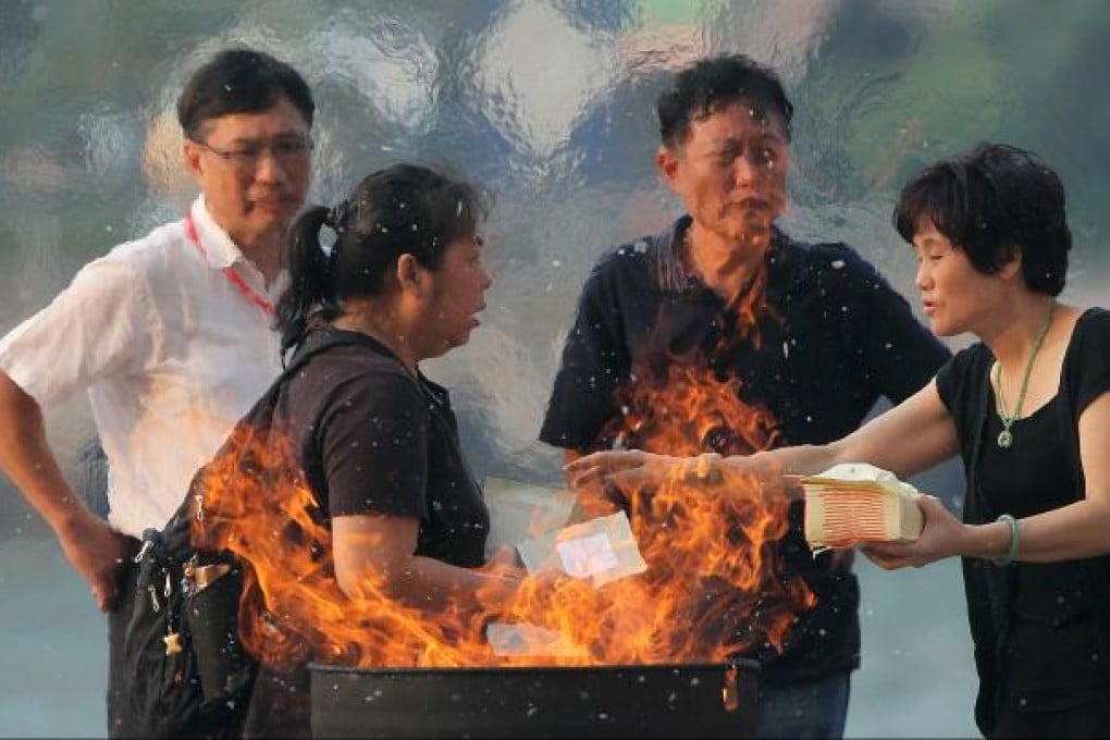 Family members of victims in the deadly Oct. 1 ferry crash in Hong Kong burn paper offerings in a ceremony held on Lamma island on Oct. 4, 2012. Photo: SCMP/K.Y. Cheng