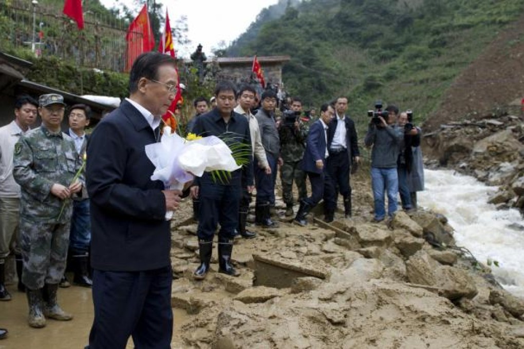 Chinese Premier Wen Jiabao pays a floral tribute to the 19 who died in the landslide. Photo: Xinhua